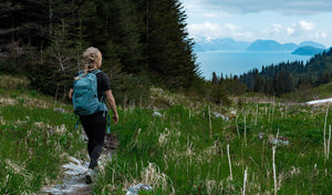 woman walking on trail with backpack